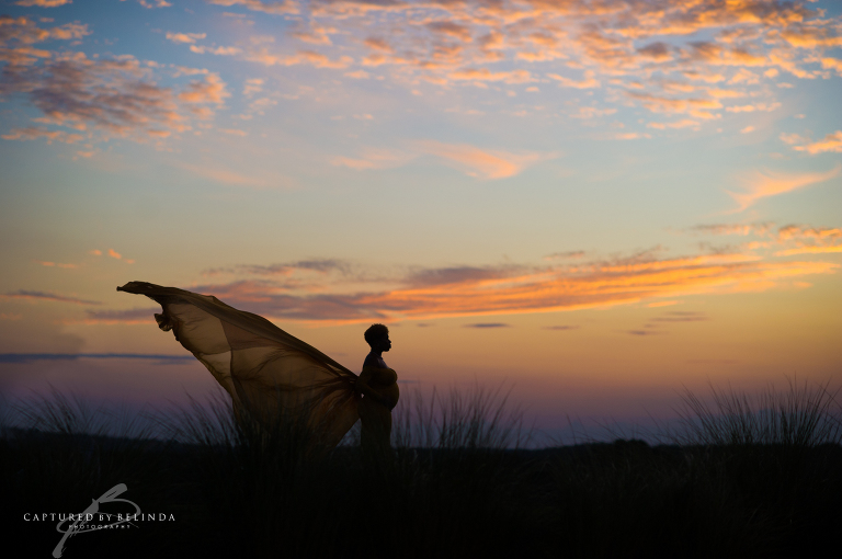 Mama to be in Awe against the sunset sky 